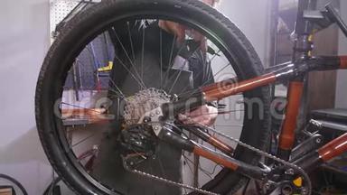 自行车服务理念.. 一个年轻人在车间修理和保养一辆自行车